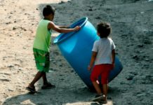 Niños hondureños víctimas de Eta e Iota bañan en pestilentes aguas estancadas