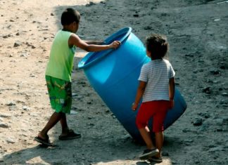 Niños hondureños víctimas de Eta e Iota bañan en pestilentes aguas estancadas