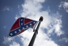 Aficionados de NASCAR ondean la bandera confederada afuera de la pista