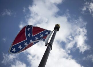 Aficionados de NASCAR ondean la bandera confederada afuera de la pista