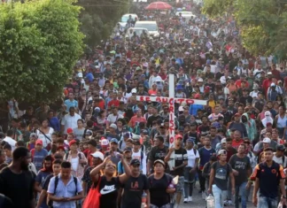 Migrantes piden fin a su sufrimiento con un viacrucis en la frontera de México con EE. UU.